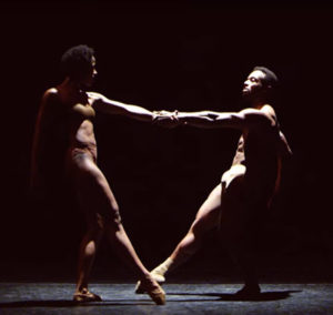 Male and female dancer standing lean back as they hold each other by one hand