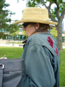 Close up of JAJ in straw hat & green canvas jacket with oak leaf appliques