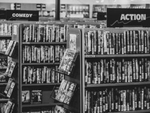 Black and white photo of VHS videos on store shelves