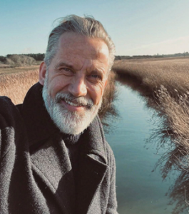 Stephen Richards artist. White middle aged male with with hair and beard smiles.